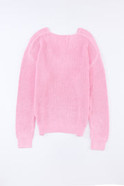 Relaxed knit V-neck pullover sweater in blush pink acrylic with ribbed texture and long sleeves.