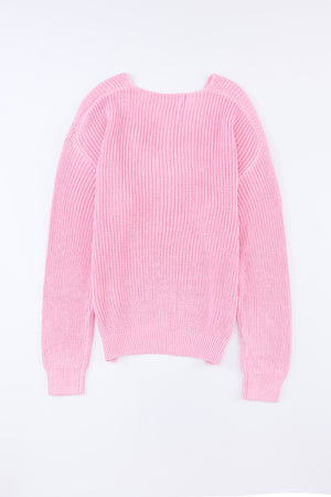 Relaxed knit V-neck pullover sweater in blush pink acrylic with ribbed texture and long sleeves.