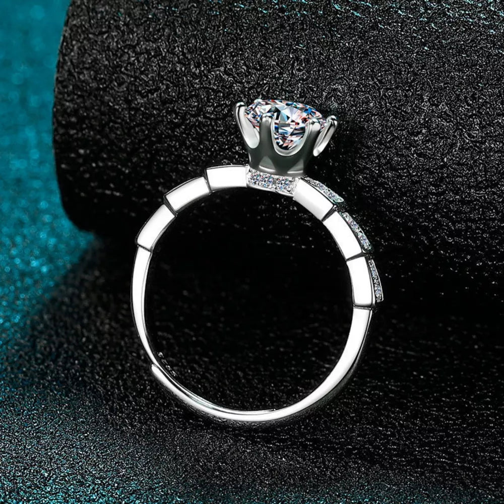 Exquisite moissanite and sterling silver ring with brilliant cut stone and pavé band.