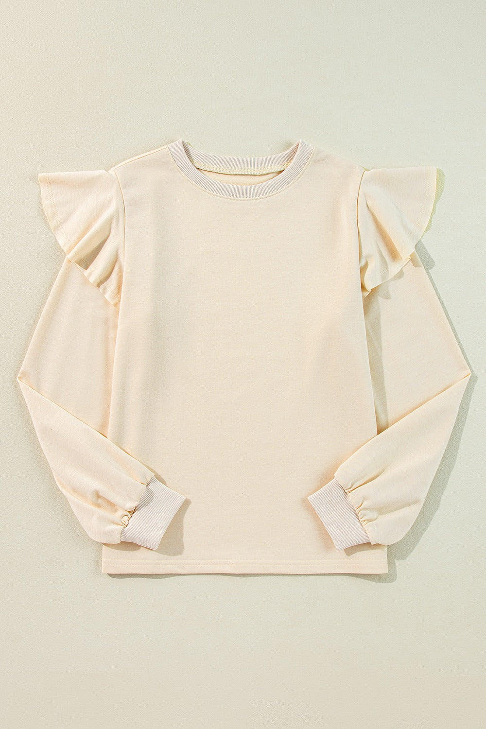 Cream ruffled shoulder sweatshirt with ribbed cuffs and crew neck.