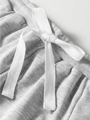 Grey cotton drawstring lounge set detail with white tie and lace trim.