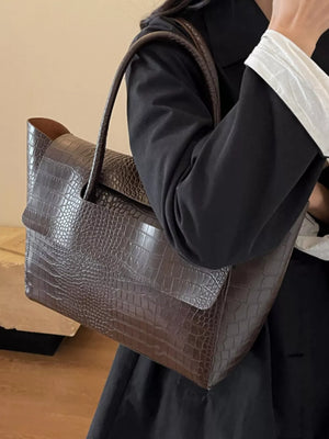 Brown crocodile-embossed medium tote bag with a structured flap and single strap.