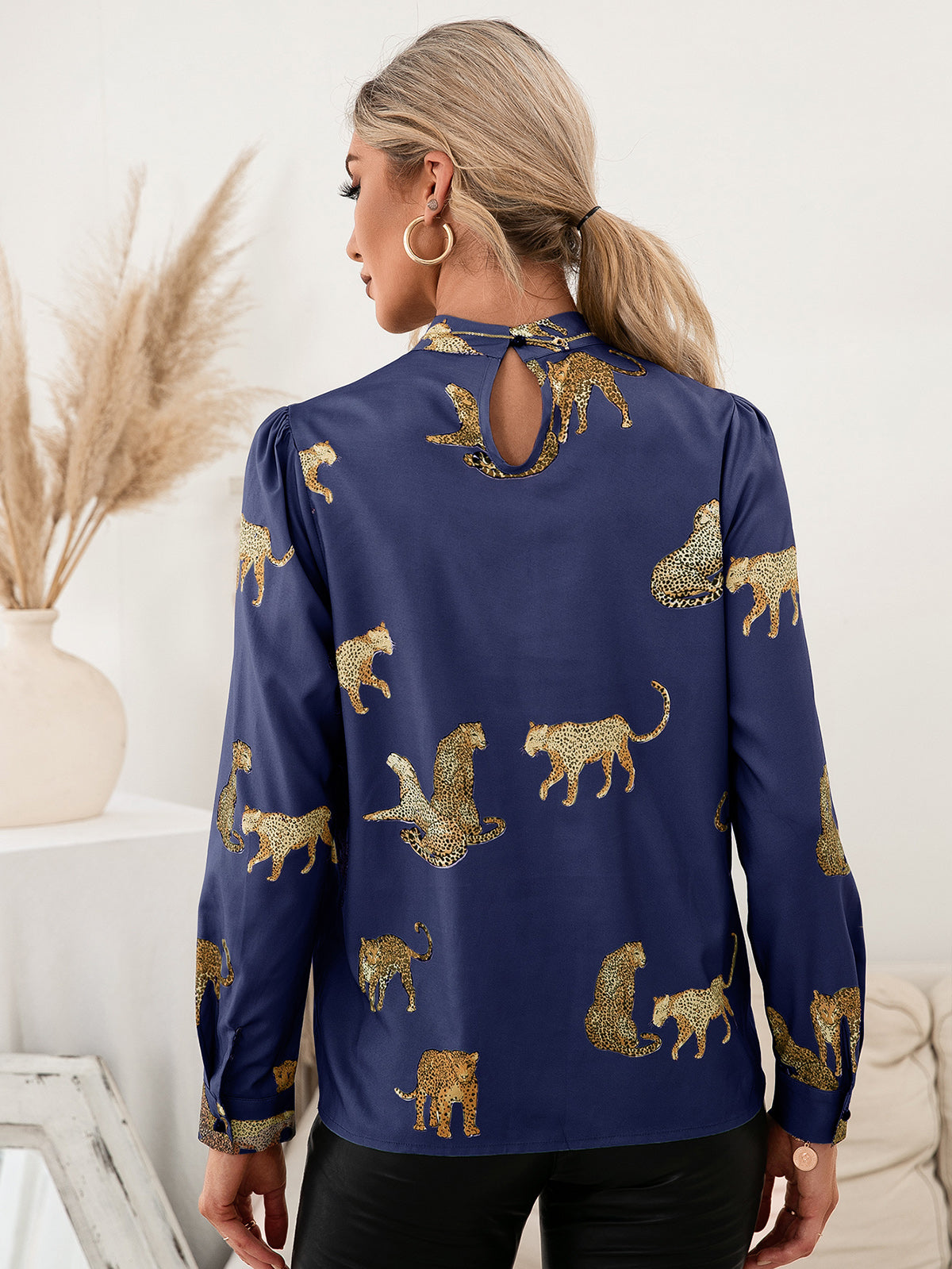 Royal blue leopard print blouse with keyhole neck detail and puff sleeves.