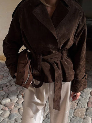Brown suede trench coat with lapel collar, tie waist, and belted detail.