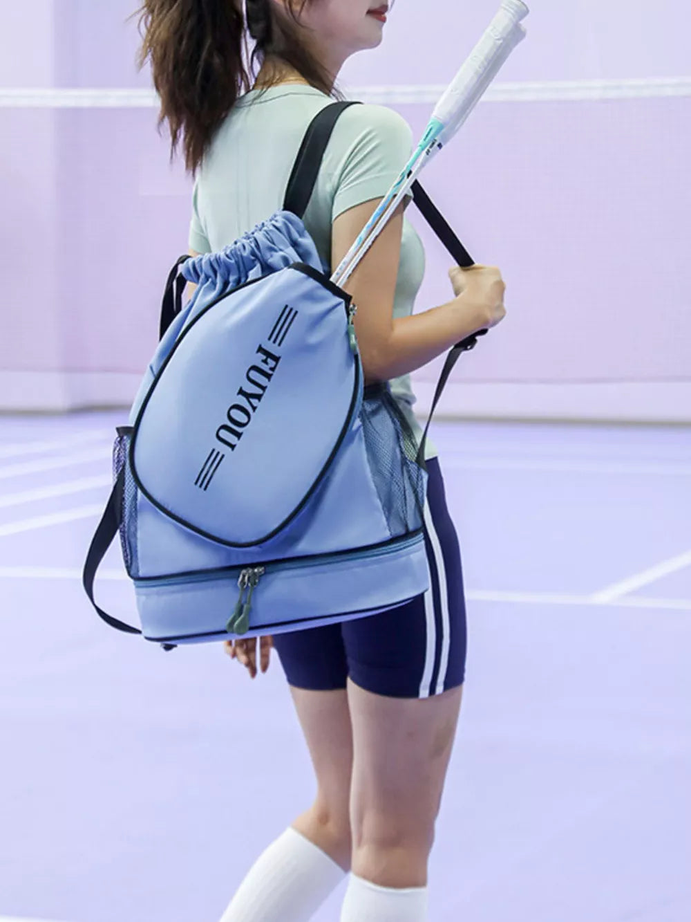 Blue drawstring backpack with racket compartment and mesh side pockets.