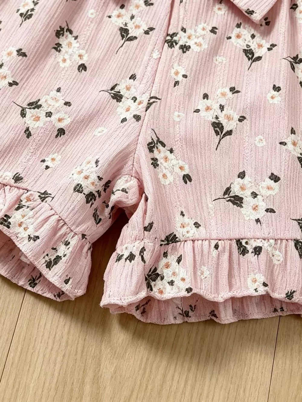 Pink floral ruffle baby romper with a bow detail