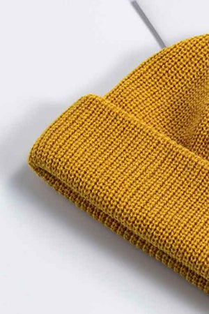 Mustard yellow ribbed knit beanie with a turn-up cuff.
