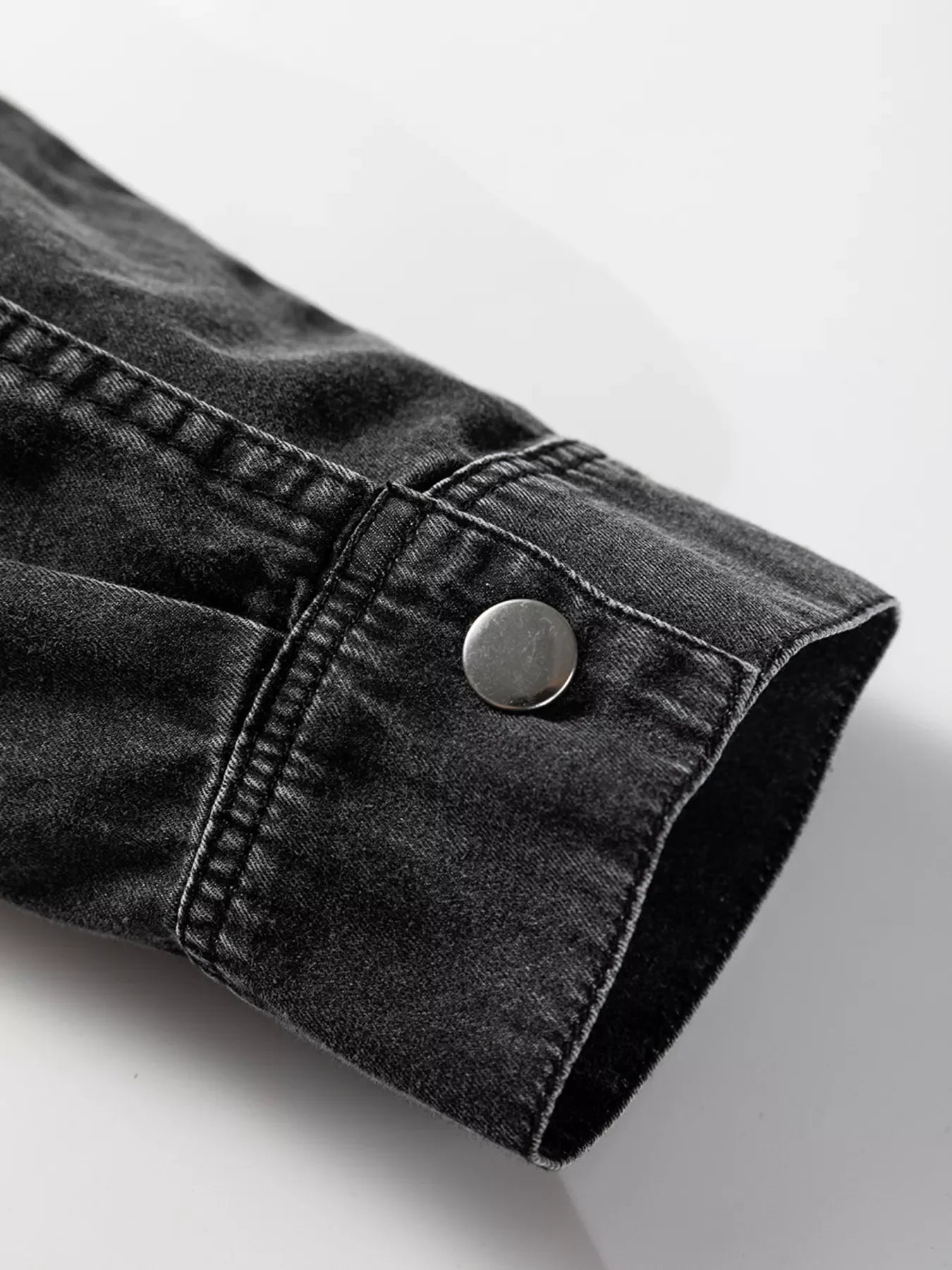Black denim button-up dress with raw hem detail and silver button cuff.