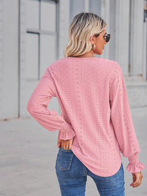 Blush pink eyelet blouse with lace trim and ruffled cuffs.