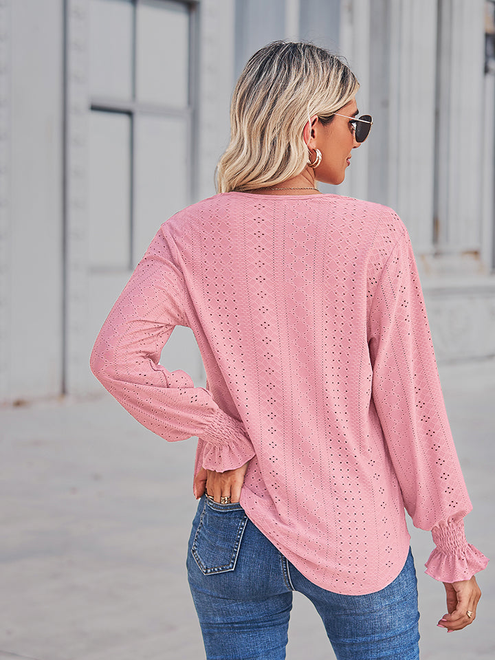 Blush pink eyelet blouse with lace trim and ruffled cuffs.