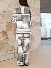 White geometric print resort co-ord set with buttoned short sleeve shirt and wide leg pants.