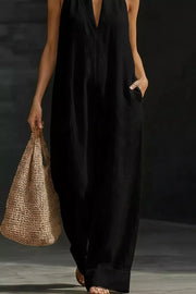 Black halter-neck maternity jumpsuit with pockets, v-neck, and wide legs.