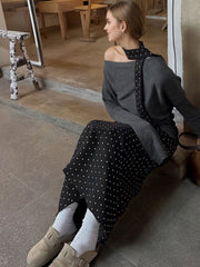 Black polka dot skirt with a grey one shoulder top and polka dot detail.