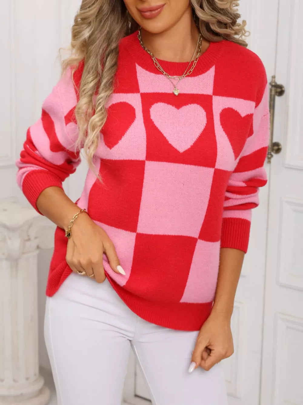 Red and blush pink checkerboard knit sweater with heart details.