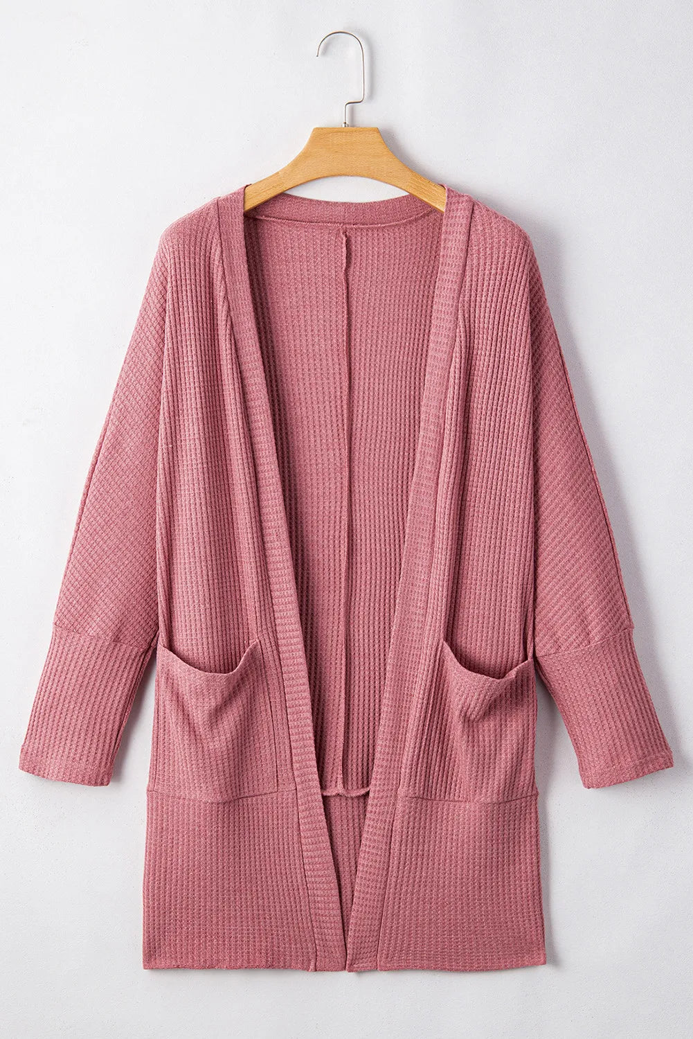 Dusty pink waffle knit open front cardigan with pockets and long sleeves.