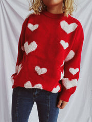 Red acrylic knit sweater with textured white heart appliqués.