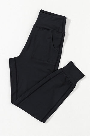 Black joggers with performance fit, pockets, and cuffed ankles.