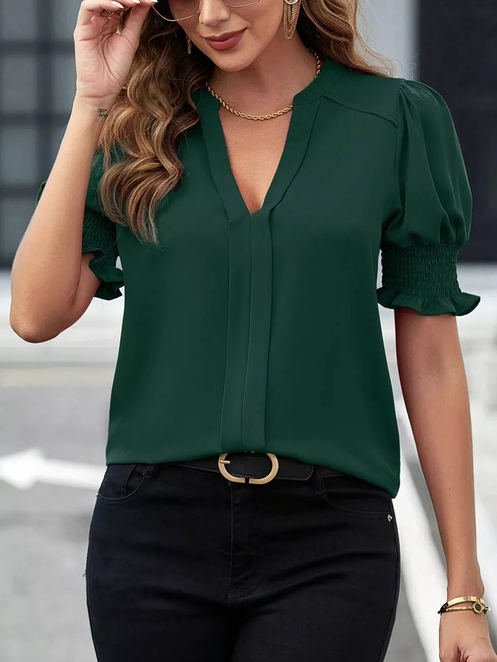 Sophisticated green blouse with notched V-neck, puffed sleeves, and smocked cuffs.