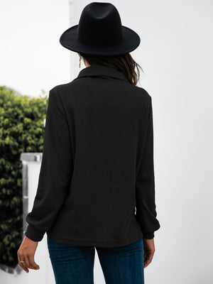 Black long sleeve tee with textured fabric and button detail.