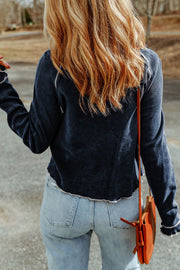 Navy waffle knit raglan sweater with ruffled cuffs and contrast stitching.