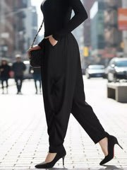 Black ribbed casual pants with pockets, styled with a black top and heels.