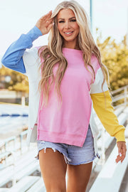 Colorblock sweatshirt in blush pink, white, blue, and yellow with split hem and crew neck.