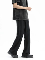 Men's black sweatpants with a relaxed fit and straight leg, styled with a t-shirt and chunky shoes.