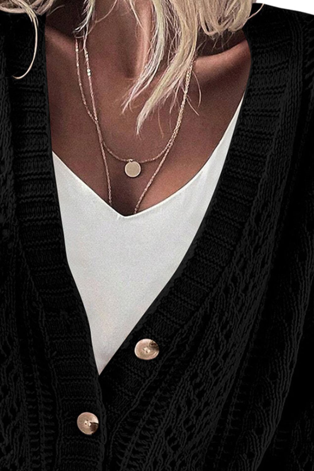 Black knit cardigan with mesh detail and button front, layered over a white cami.