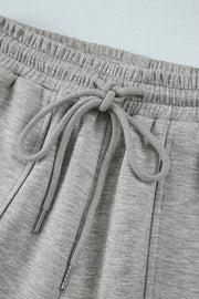 Gray wide-leg lounge trousers with elastic waistband and drawstring detail.
