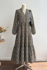 Chic black midi dress with animal print, V-neck, balloon sleeves, and tiered skirt.