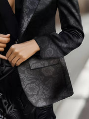Black lapel collar slim fit blazer with tonal floral pattern and pocket detail.