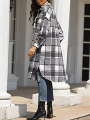 Plaid longline trench coat in grey with button-down front and pockets, worn open over jeans.