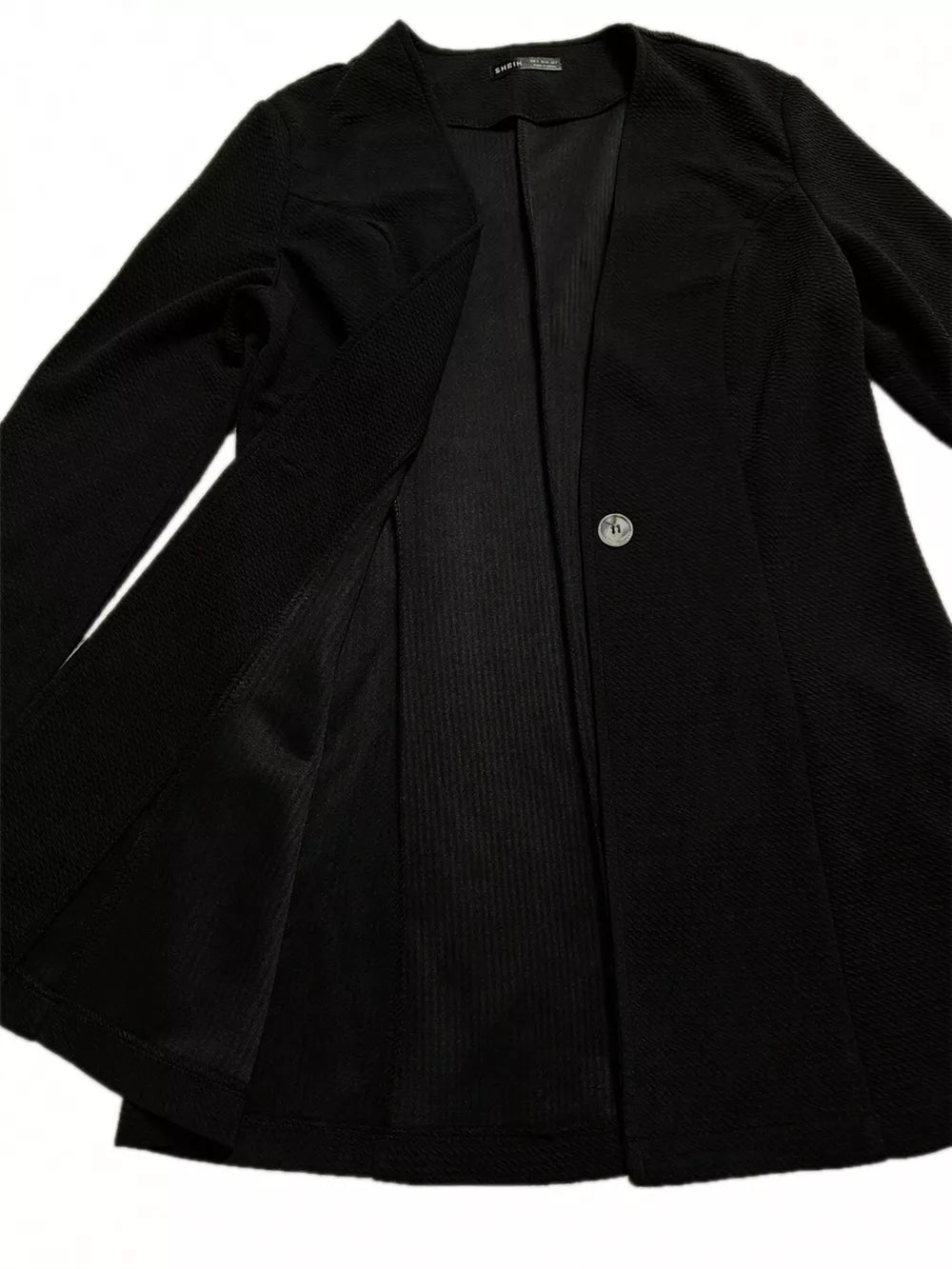 Black single-button blazer with textured fabric and tailored fit