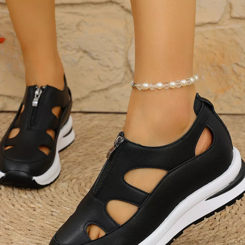 Black cutout wedge sneakers with zipper detail and chunky sole.