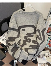 Gray oversized sweater with abstract dark gray pattern and ribbed hem.