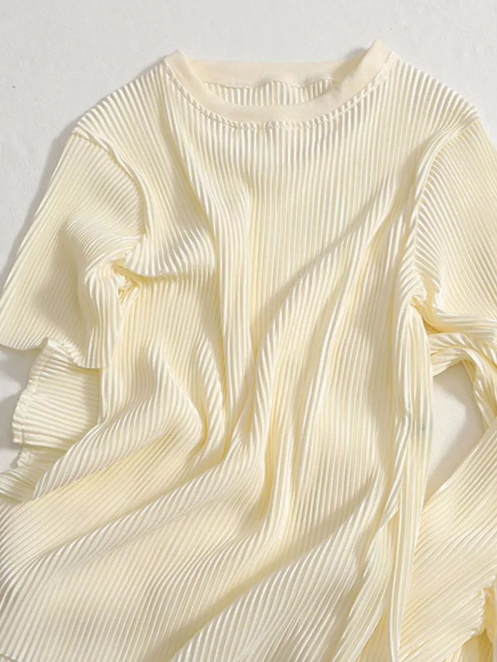 Elegant apricot pleated two-piece set with a crew neck and short sleeves.