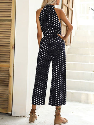 Navy polka dot halter romper with wide legs and a belted waist.