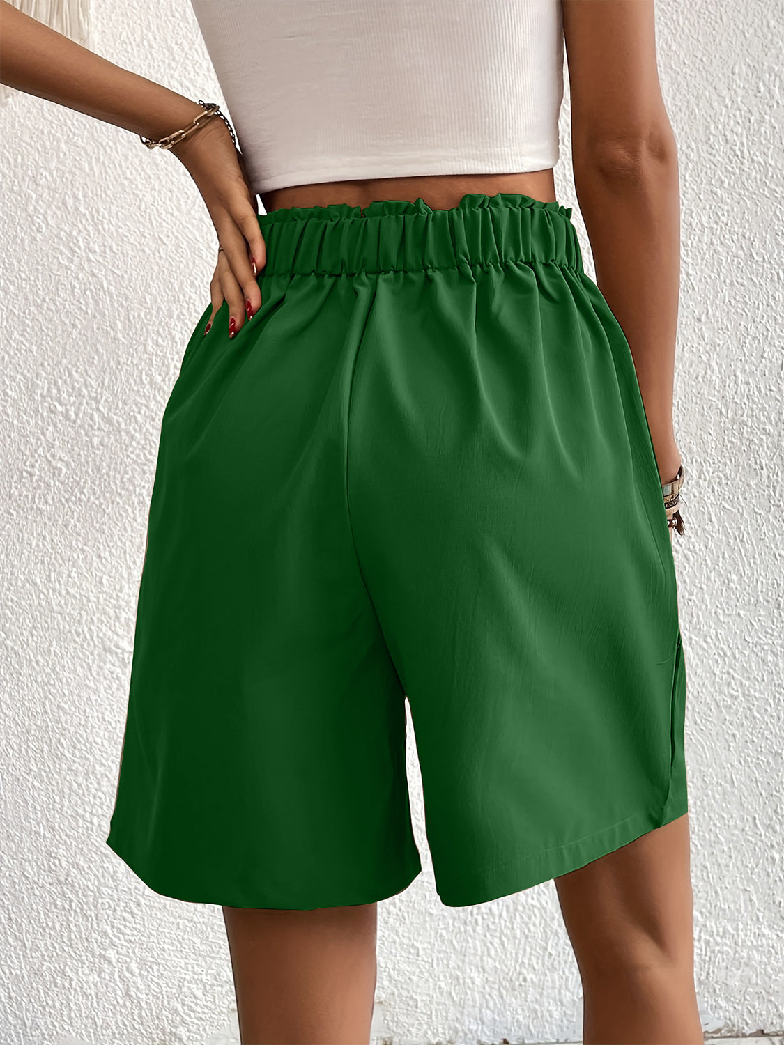 Pleated front bermuda shorts in dark green with elastic waist and side pockets.