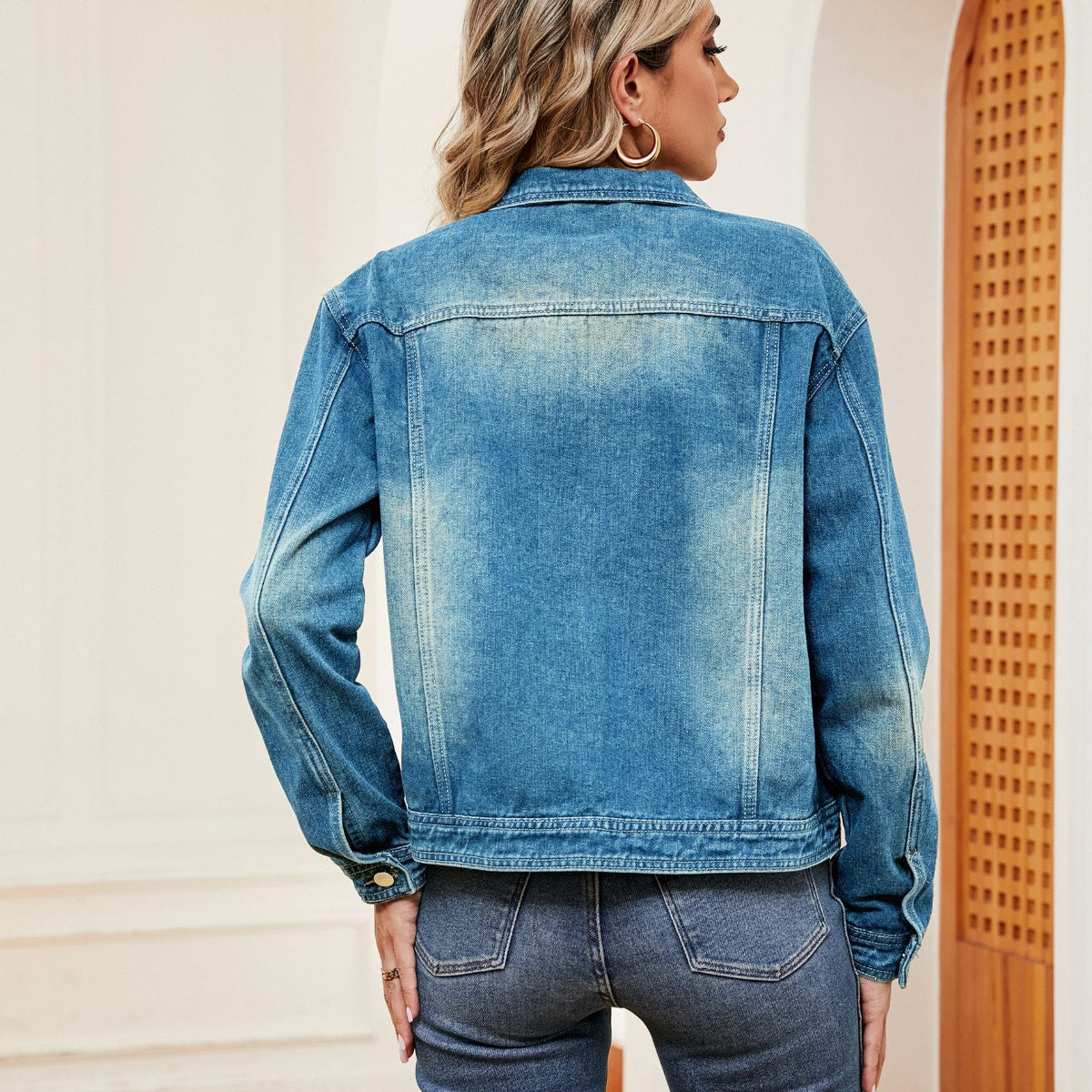 Faded wash denim trucker jacket with a classic collar and button cuffs.