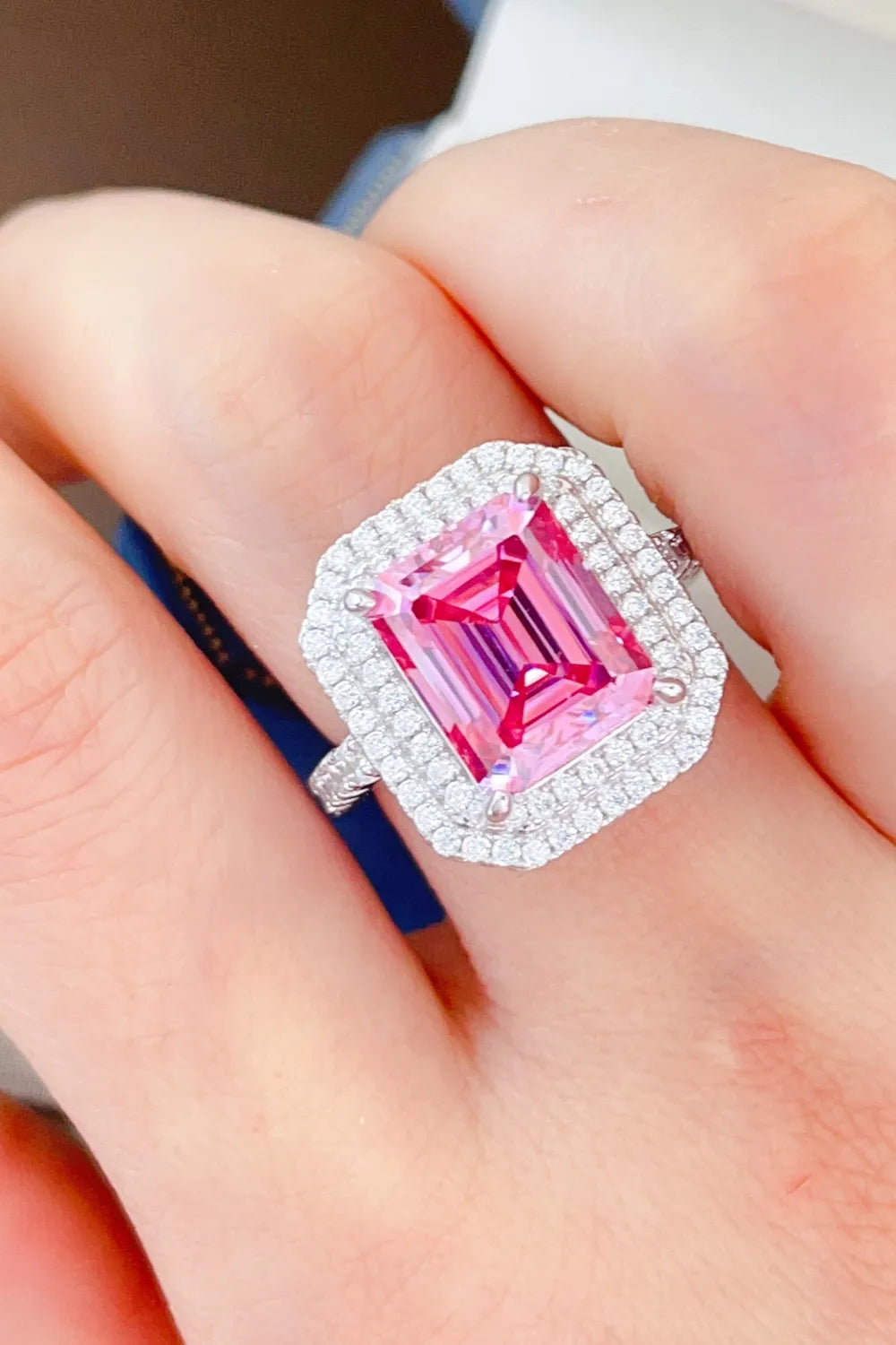 Hot pink emerald cut halo ring with pave diamond band.