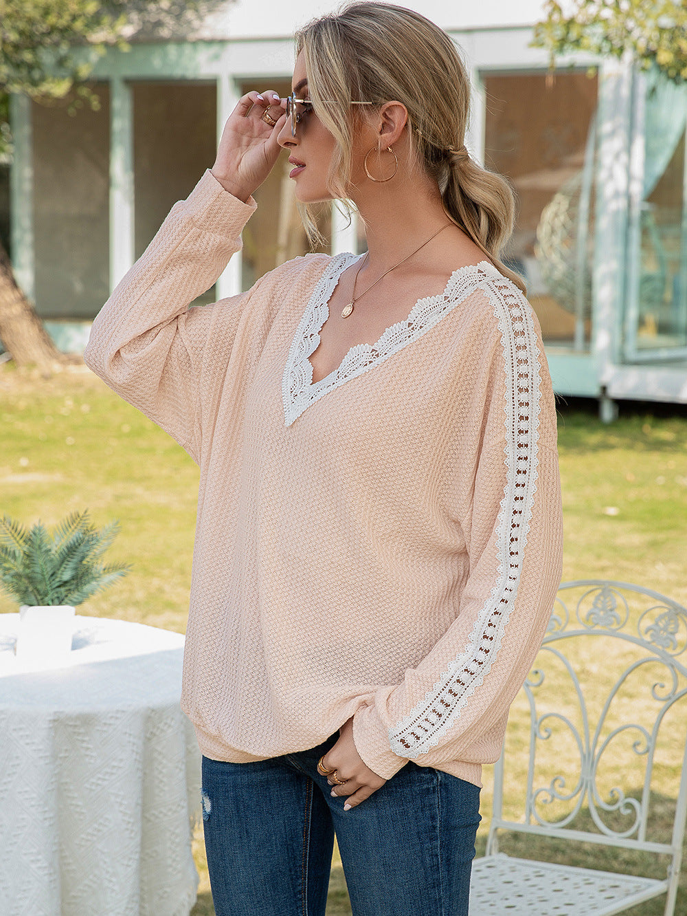 Apricot waffle knit v-neck top with white lace trim on neckline and sleeves.