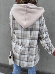 Oversized plaid shacket with attached hood in beige and white, styled with jeans.