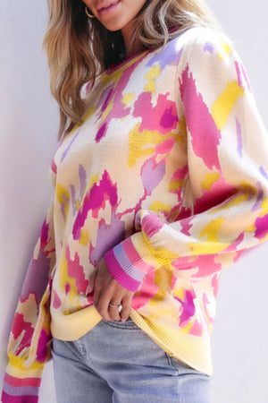Abstract brushstroke knit sweater with puff sleeves and striped cuffs in floral colors.