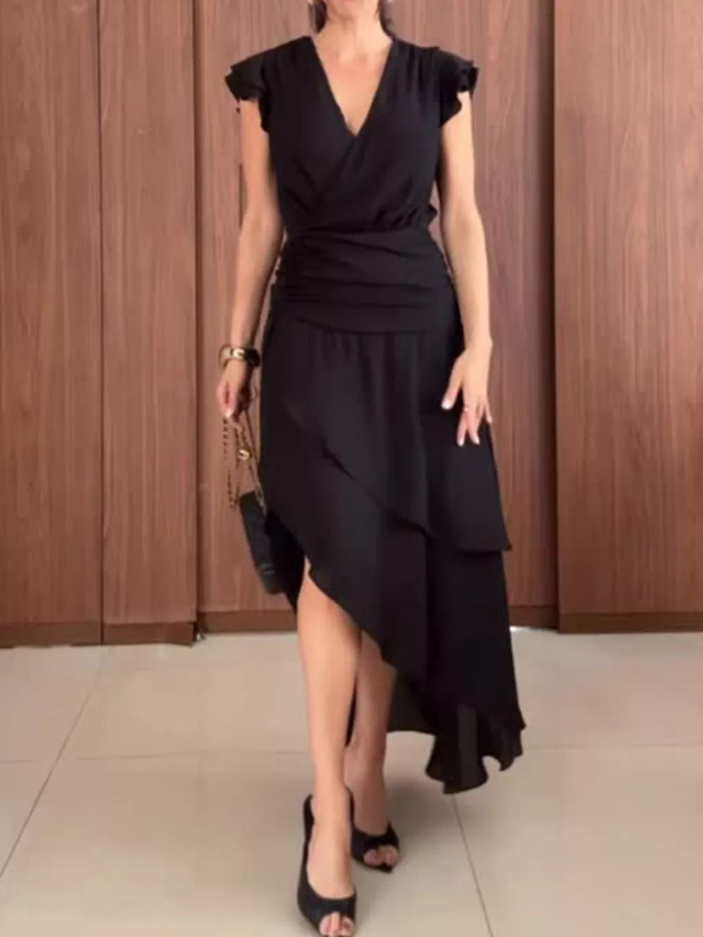 Black asymmetrical ruffle hem dress with cap sleeves and cinched waist.
