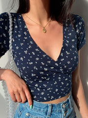 Dark blue floral print crossover crop top with short sleeves and a deep V-neck.