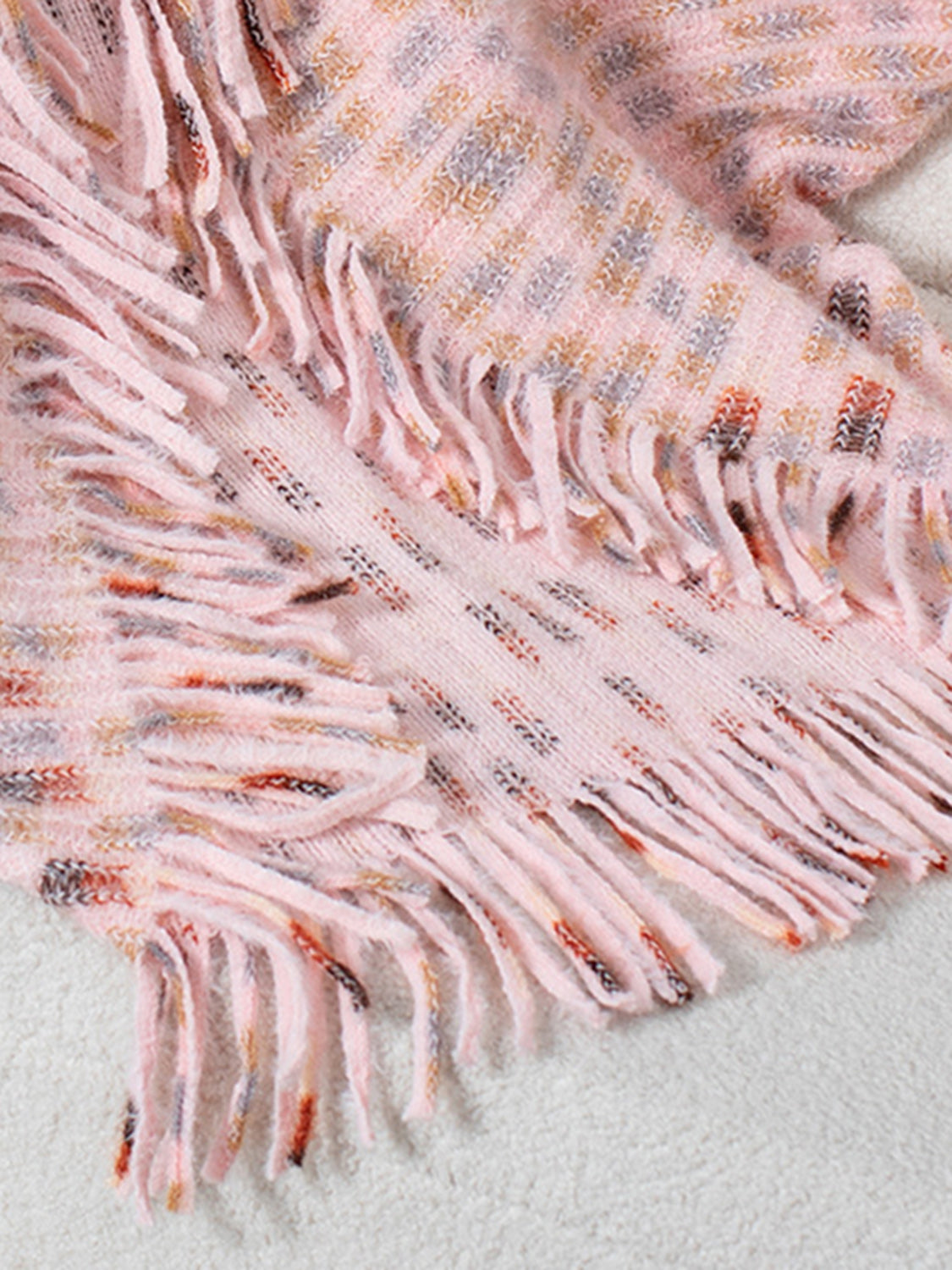 Textured fringe shawl cardigan in blush pink acrylic with a subtle patterned knit and fringe detail.