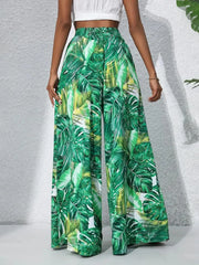Green tropical leaf print palazzo trousers in 100% polyester with a wide leg.