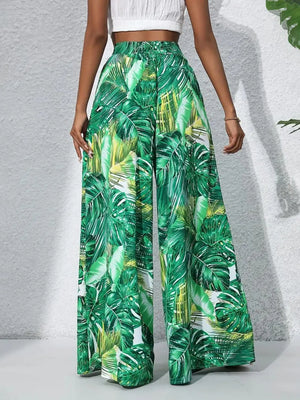 Green tropical leaf print palazzo trousers in 100% polyester with a wide leg.