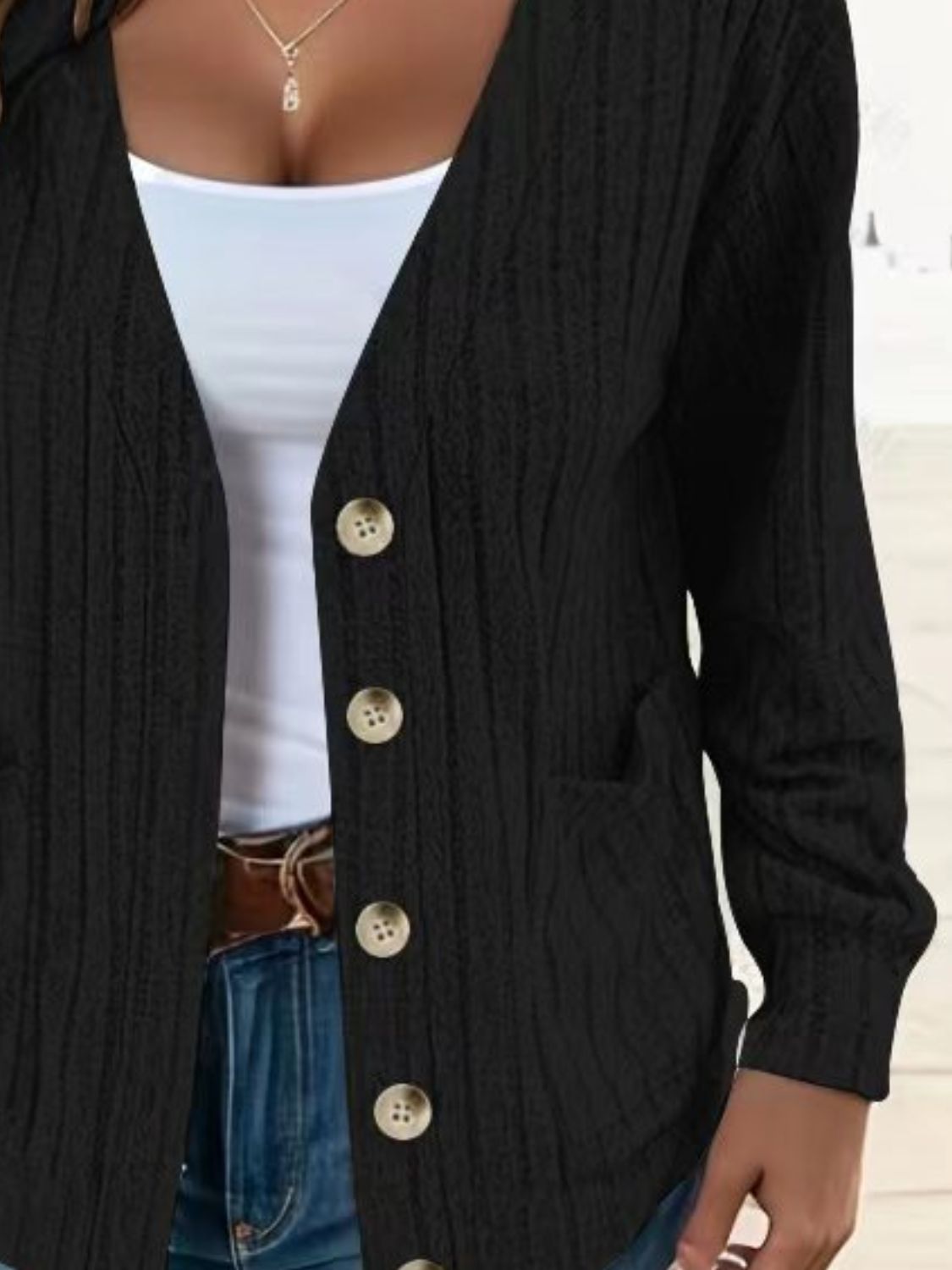 Black ribbed knit button-down cardigan with pockets and tan buttons.