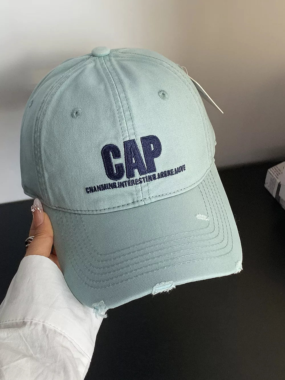 Mint green cotton baseball hat with distressed details and embroidered CAP text.